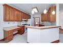 Bright kitchen with tiled floors, wooden cabinets, white appliances, and a breakfast bar at 98 Country Acres Ct, Mcdonough, GA 30253