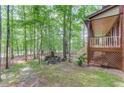 Backyard featuring a stone pathway, terraced planting beds, and mature trees, leading to covered deck at 4975 Duncans Lake Dr, Buford, GA 30519
