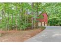 Brick home with three-car garage, surrounded by lush trees and a long driveway at 4975 Duncans Lake Dr, Buford, GA 30519