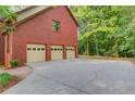 Three car garage with ample parking space, next to the lush green scenery at 4975 Duncans Lake Dr, Buford, GA 30519