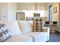 Living room with kitchen view with stainless steel appliances, white cabinetry and granite countertops at 1195 Milton Se Ter # 1109, Atlanta, GA 30315