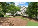 Stately home nestled among mature trees features a well-maintained lawn and mulched landscape with a symmetrical facade at 4223 N Mountain Ne Rd, Marietta, GA 30066