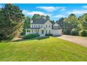 Two-story home featuring a covered front porch, attached garage, well-manicured lawn and mature shade trees at 185 Waverly Walk, Douglasville, GA 30134
