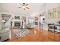 Bright living room featuring hardwood floors, a fireplace, neutral walls, and a ceiling fan at 758 Beranda Cir, Douglasville, GA 30134