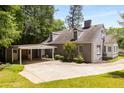 Rear exterior view showcasing a carport and landscaped yard surrounding the grey brick home at 6596 Wright Ne Rd, Atlanta, GA 30328