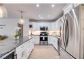 Bright kitchen with stainless steel appliances, white cabinets, granite countertops, recessed lighting, and hardwood flooring at 705 Berry Ct, Villa Rica, GA 30180