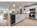 A modern kitchen features white cabinets, stainless steel appliances, a kitchen island, and an open layout into the living area at 705 Berry Ct, Villa Rica, GA 30180