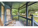 Inviting covered porch with rocking chairs and view of the landscaped front yard at 9760 Loblolly Ln, Roswell, GA 30075