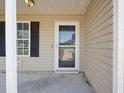 Close-up of the front door with a storm door, black shutters, and beige siding at 3645 Ten Oaks Cir, Powder Springs, GA 30127
