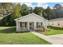 Charming single-story home with a well-manicured lawn, inviting entryway, and mature trees at 3645 Ten Oaks Cir, Powder Springs, GA 30127