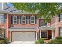 Charming brick home featuring a two-car garage, black shutters, and well-maintained landscaping at 4905 Village Green Dr, Roswell, GA 30075