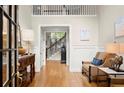 Bright foyer boasts hardwood floors, wainscoting, high ceilings, and decorative furnishings at 4905 Village Green Dr, Roswell, GA 30075