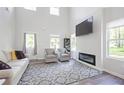 Bright living room with a fireplace, large windows, tall ceilings and stylish furniture at 115 Haven Brook Way, Douglasville, GA 30134