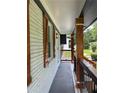 View of the home's covered porch, featuring wood accents and a black railing, offering a cozy outdoor space at 3640 Narron Dr, Atlanta, GA 30331