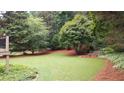 Backyard features an expansive lawn with lush trees and landscaping at 161 Highgrove Dr, Suwanee, GA 30024