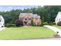 Beautiful two-story brick home with a spacious lawn and mature trees at 161 Highgrove Dr, Suwanee, GA 30024