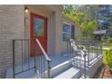 Close-up view of a charming front porch with a red door and seating area at 2115 Pinehurst Dr, East Point, GA 30344