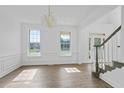 Sun-filled formal room featuring a decorative chandelier, pristine white walls, and wood-look floors at 327 Awendaw Cir, Ellenwood, GA 30294