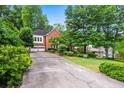 Long driveway leading to a brick home with a two-car garage and mature trees at 2610 Chadwick Rd, Marietta, GA 30066