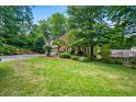 Brick home with a well-manicured lawn and lush landscaping, including mature trees at 2610 Chadwick Rd, Marietta, GA 30066