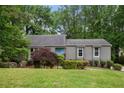 Single-story house with a light-blue front door and a green lawn surrounded by mature trees at 3006 Alberta Dr, Marietta, GA 30062