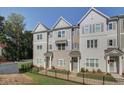 Modern townhome exterior with a combination of brick and siding, professional landscaping, and a fenced yard at 3338 Cranston Ln, Kennesaw, GA 30144