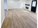 Bright living room featuring hardwood floors and a cozy fireplace at 681 Burtons Cv, Hampton, GA 30228