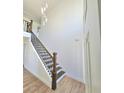 Elegant staircase with wood and black iron railings at 681 Burtons Cv, Hampton, GA 30228
