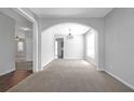 Bright dining area featuring an arched doorway, carpet flooring, and modern chandelier at 145 Silver Mine Trl, Austell, GA 30168