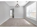 Sunny dining room with modern chandelier, carpet, and large windows offering ample natural light at 145 Silver Mine Trl, Austell, GA 30168