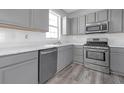 Kitchen boasts stainless steel appliances, sleek countertops, and gray cabinetry at 145 Silver Mine Trl, Austell, GA 30168
