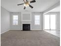 Spacious living room with a ceiling fan, fireplace, and sliding glass doors for natural light at 145 Silver Mine Trl, Austell, GA 30168