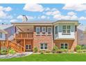 Back exterior with a large deck and stairs leading to a well-manicured lawn and garden area at 980 Windsor Place Cir, Grayson, GA 30017