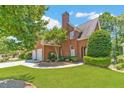 Brick home featuring a two-car garage, manicured lawn, and mature trees in a suburban neighborhood at 980 Windsor Place Cir, Grayson, GA 30017