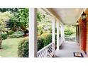 Inviting covered porch with classic white columns and view of landscaped yard at 1477 Triple Creek Nw Ct, Kennesaw, GA 30144