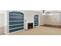 Spacious living room featuring a fireplace, built-in shelving, and a ceiling fan at 3544 Chestatee Dr, Marietta, GA 30062