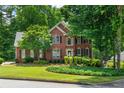 Charming two-story brick home featuring black shutters, manicured landscaping, and a lush green lawn at 3642 Fowler Rdg, Douglasville, GA 30135
