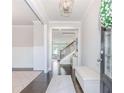 Bright entryway features a decorative light fixture, white trim, wainscoting and dark wood floors at 431 Hinton Farm Way, Dacula, GA 30019