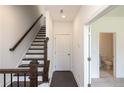 Staircase features hardwood steps with a dark wood railing and a conveniently located bathroom on the main level at 502 Healy Dr # 76, Cumming, GA 30040