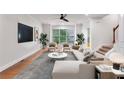 Bright living room with large windows, modern furnishings, and a sleek ceiling fan at 275 Blue Pointe Ct, Suwanee, GA 30024