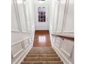 View of the carpeted staircase with white trim, leading to a door with natural light at 275 Blue Pointe Ct, Suwanee, GA 30024