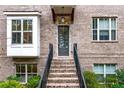 Charming brick townhome entrance featuring a stylish door, brick steps, and a bay window at 3786 Alstead Manor Way, Suwanee, GA 30024