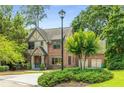 Beautiful front yard with a light post, manicured bushes, large trees, and a charming two-story brick home at 504 S Westminster Ne Way, Atlanta, GA 30307