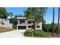 Contemporary home featuring a clean white facade, a balcony, a black garage door, and a neatly landscaped front yard at 1610 Niskey Lake Rd, Atlanta, GA 30331