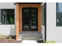 Modern front door with glass panels, wood accents, and a stone walkway leading to the entrance of the home at 1610 Niskey Lake Rd, Atlanta, GA 30331