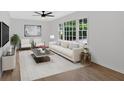 Bright living room with large windows, ceiling fan, modern furniture, and stylish decor at 5689 Woodland Dr, Acworth, GA 30102