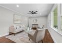 Cozy living room features hardwood floors, neutral paint, ceiling fan, and large windows at 3180 Rehoboth Dr, Decatur, GA 30033