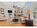 Cozy living room with a stone fireplace, hardwood floors, and large windows with plantation shutters at 388 Golf Crest Dr, Acworth, GA 30101