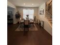 Bright dining room with hardwood floors and a round glass table at 7699 Cabrini Pl, Fairburn, GA 30213