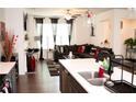 Open-concept living room featuring modern decor and dark-toned sectional sofa at 7699 Cabrini Pl, Fairburn, GA 30213